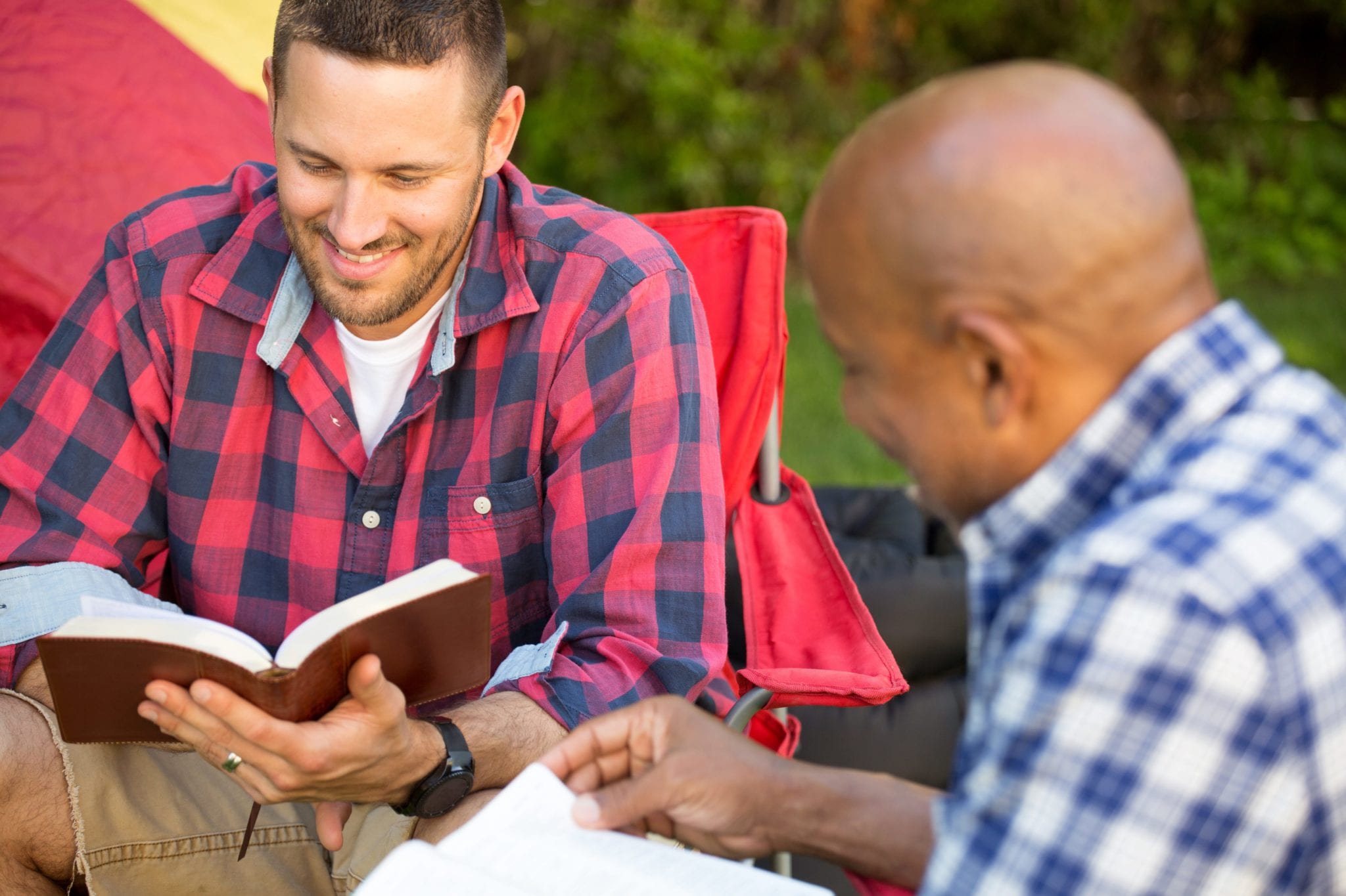 Men having a bible study on a camping trip.